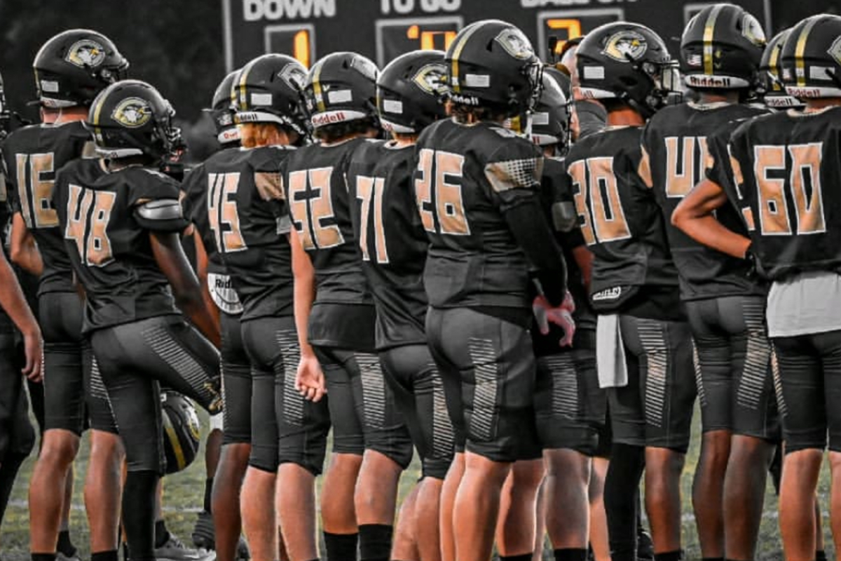 FALCON VARSITY FOOTBALL players gather before their first game of the season against the Eagles of Landstown High School. The boys hyped themselves up before hitting the field. "You have to want to win," senior captain Max Palmerton said.