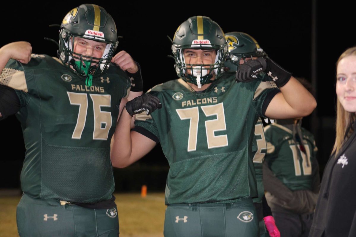 JUNIOR IAN McCLURE (left) and senior Tyler Nowotny (right) flex their win over Salem High school on Friday, October 25. They were excited for their Homecoming win.