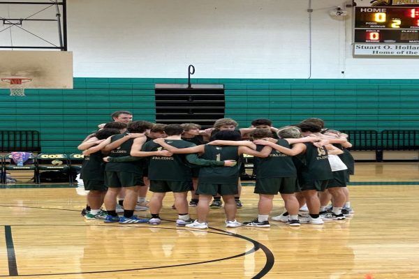 BOYS VOLLEYBALL PLAYERS huddle up before the game to hype each other up. They faced off against Tallwood High school last beating them  3-1.