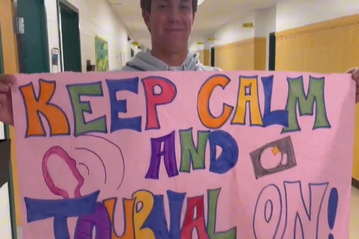 SENIOR JOURNALISM III student Brendan White holds on to the coveted Journalism recruit sign as part of this year's recruitment video; it's theme is a rendition of the popular Disney show, "Jessie". Upper level Journalism students take the time to induct new students and 'pass the torch'.