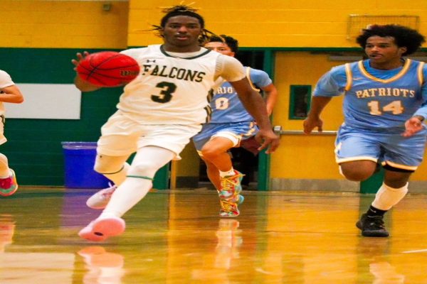 SENIOR RAYMOND WATKINS dribbles the ball down the court , heading straight for the basket. The Falcons battled long-time rival, the Patriots of First Colonial HS and won the game.