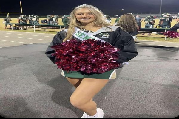 SENIOR PAYTON GIBSON cheers the football team on their senior night game. She encouraged the Falcons from the sidelines. 