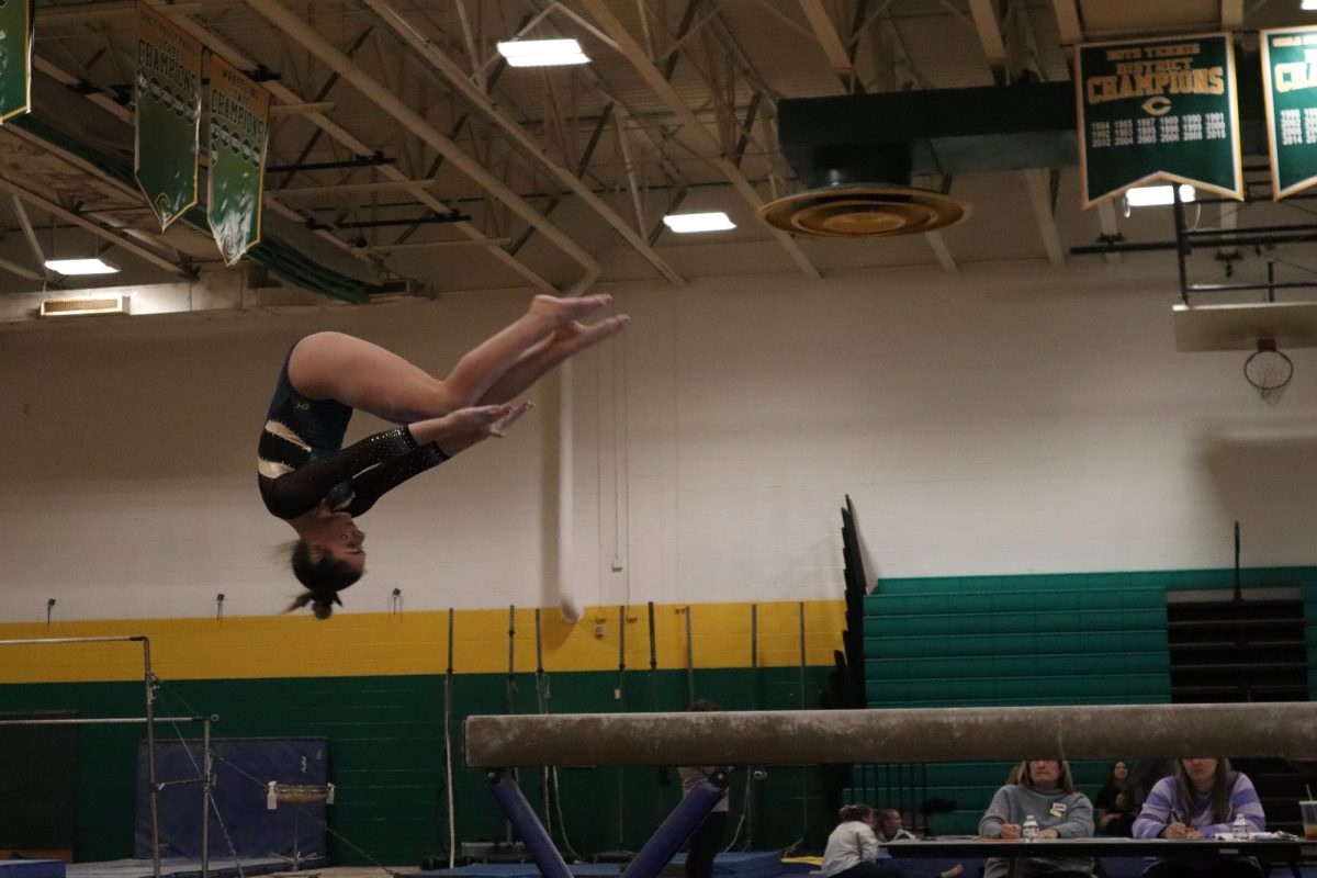 CHS FALCON GYMNAST flips off the beam as a finisher to her routine. The team has been practicing all year to perfect moves like this one.