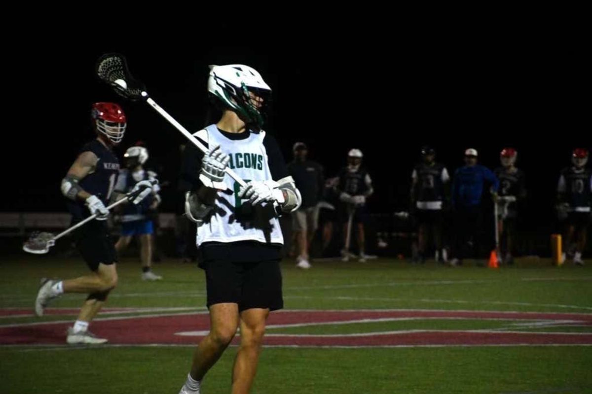 SENIOR CONNOR WARREN cradles the ball as he moves toward the goal. The Falcons worked around the Kellam Knights defense for a shot on target.