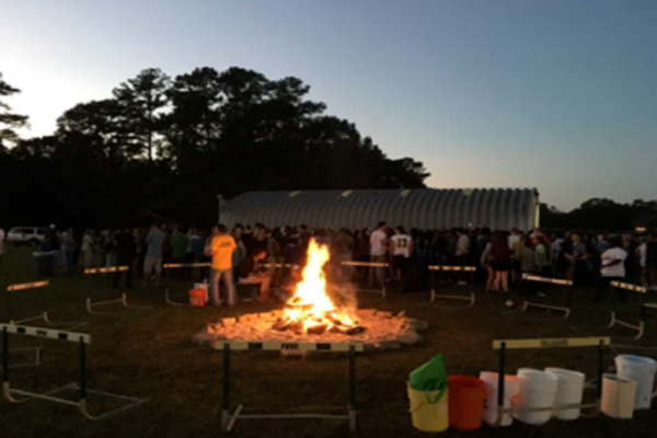 STUDENTS GATHER AROUND the bonfire to celebrate the beginning of Homecoming Week. The bonfire is a tradition that has been ongoing for many years.