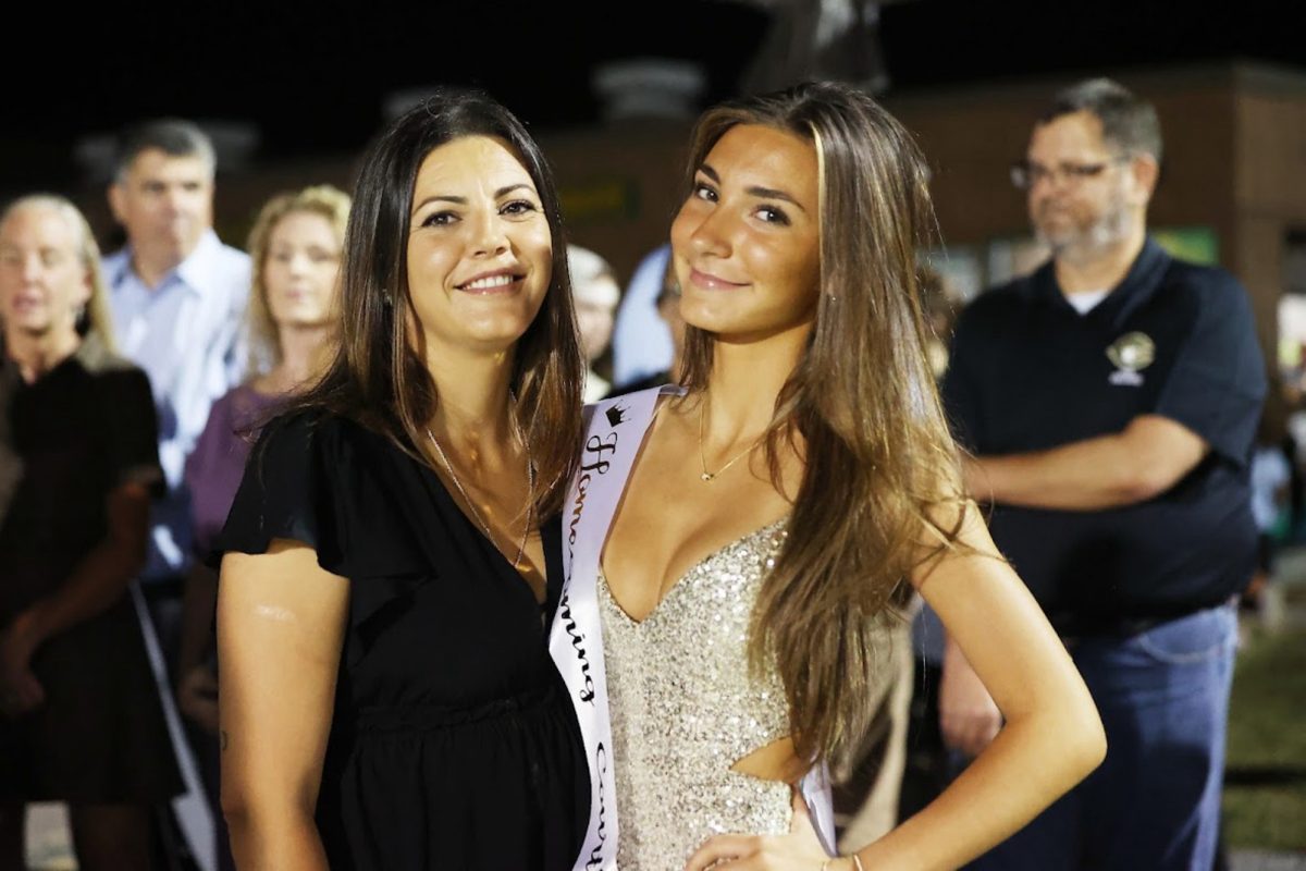 SENIOR LOLITA LOLAJ accepted Falcon Homecoming queen crown during the half-time football game. Her mom was right by her side, supporting along the way.