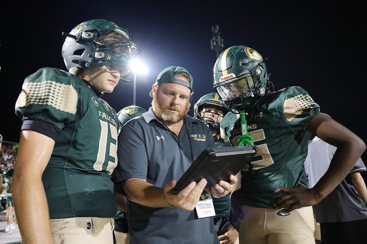JUNIOR VARSITY HEAD Coach Bank draws up a play with junior Quarterback Braden Herron. The team would later go on to score a game winning touchdown this drive. 
