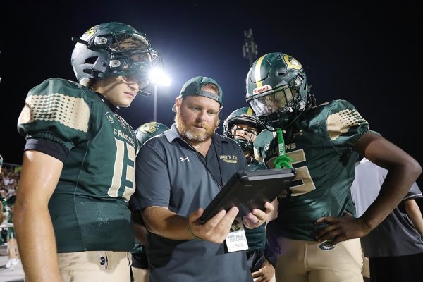 JUNIOR VARSITY HEAD Coach Bank draws up a play with junior Quarterback Braden Herron. The team would later go on to score a game winning touchdown this drive. 