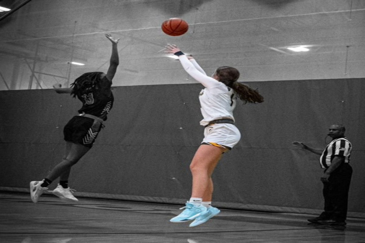 SENIOR CAPTAIN JACEY Seim jumps up to get the ball over the opposing team's player, scoring a three point shot. The Lady Falcons are led by Seim's leadership and dedication to becoming better each day.