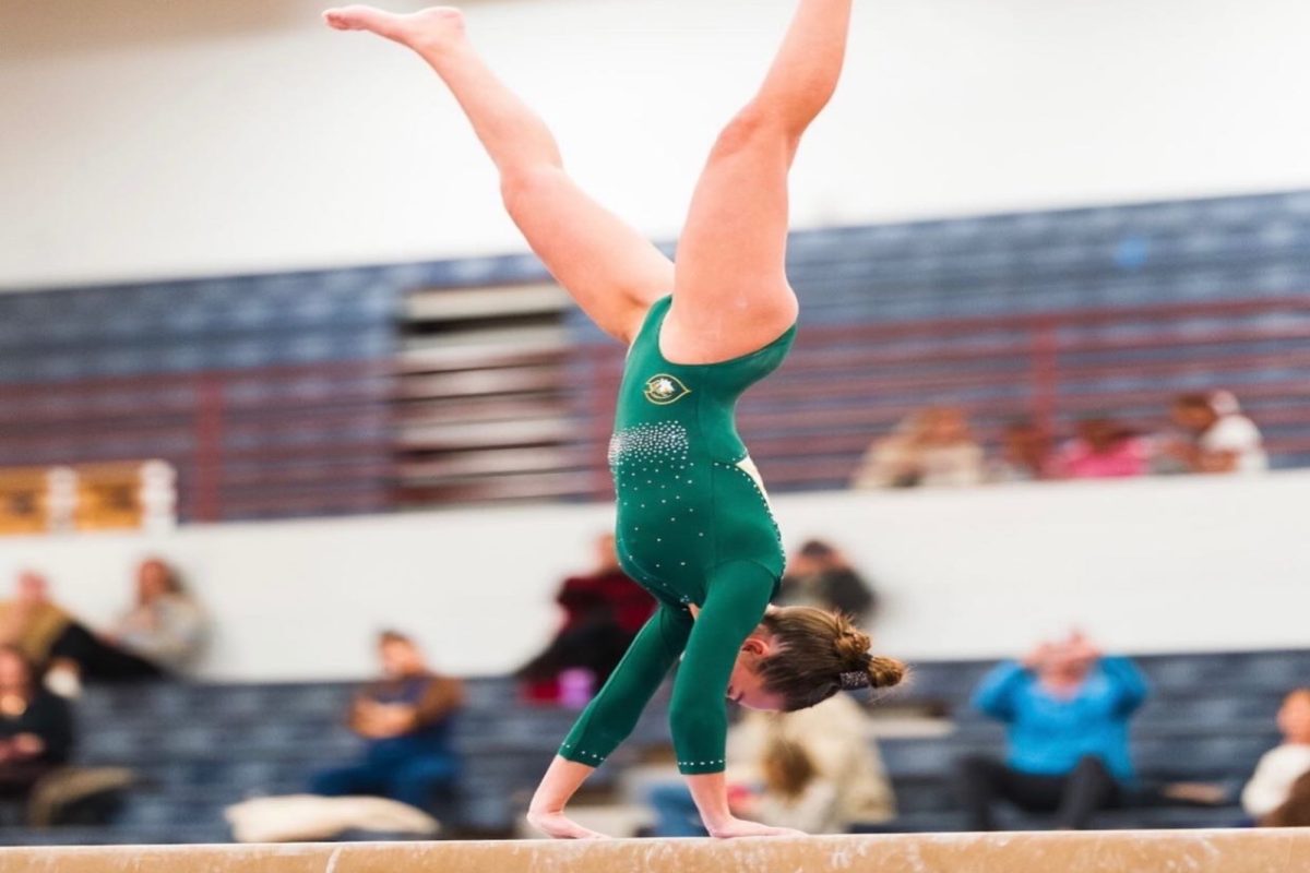 SENIOR ADDIE REKANT flips onto the beam; it's one of her specialty events. Rekant is one of the top Falcon gymnasts this season.