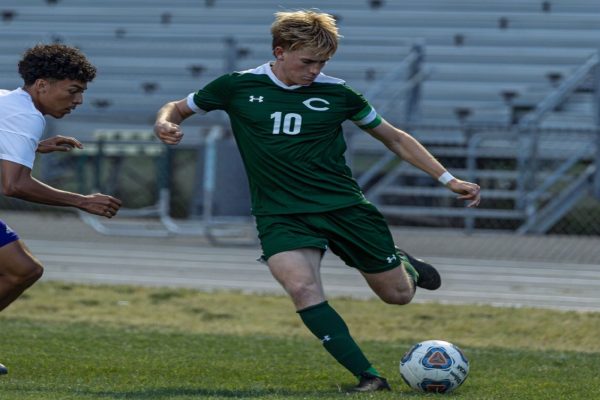 SENIOR SOCCER CAPTAIN Nate White shoots the game winning goal. White leads the team with his composure, leadership, and intense work ethic.