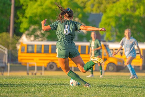 SENIOR KATHLEEN GROSZ takes a free kick, flying into the other team's defensive third. The team is led by Grosz's aggression, passion, and enthusiasm as the starting center back.