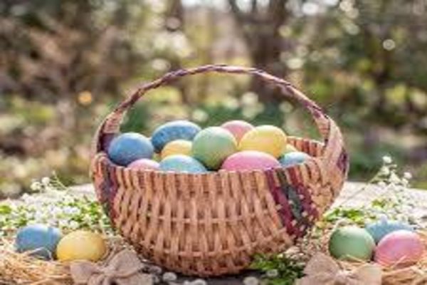 PASTEL COLORED EGGS overflow the wicker basket, waiting patiently to be placed for the Easter Egg Hunt. The cheerful spirit of springtime celebration is a welcome change from the winter weather.